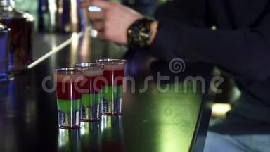 有选择地集中在酒吧桌上的三张照片上，男人在后台使用他的智能手机